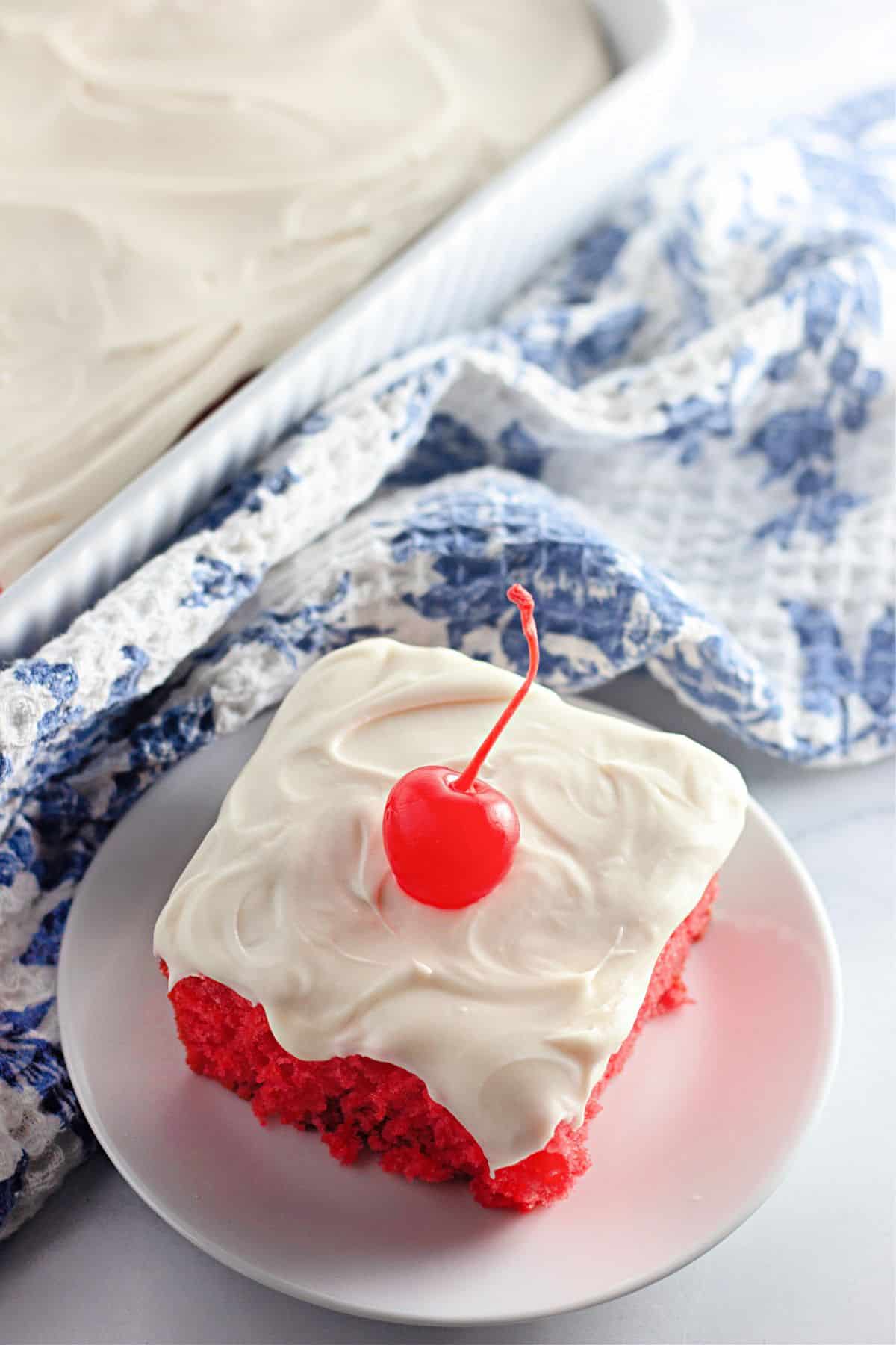 Slice of maraschino cherry cake on a plate.
