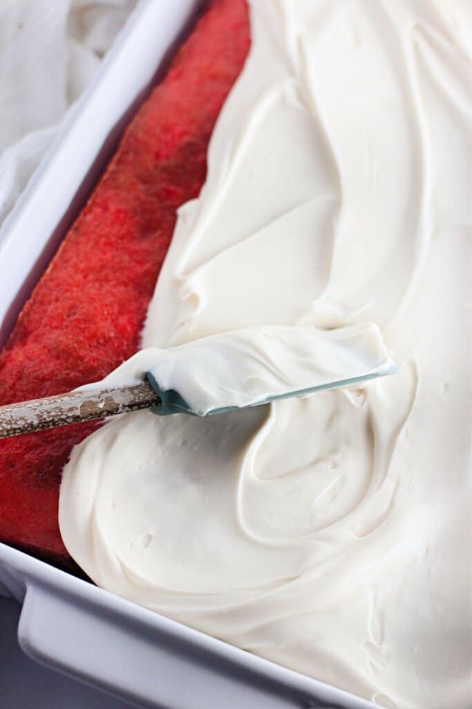 Frosting being spread on top of cake.