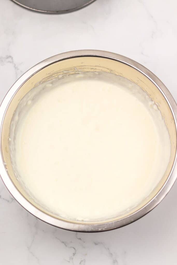 Cream being whipped in a large mixing bowl.