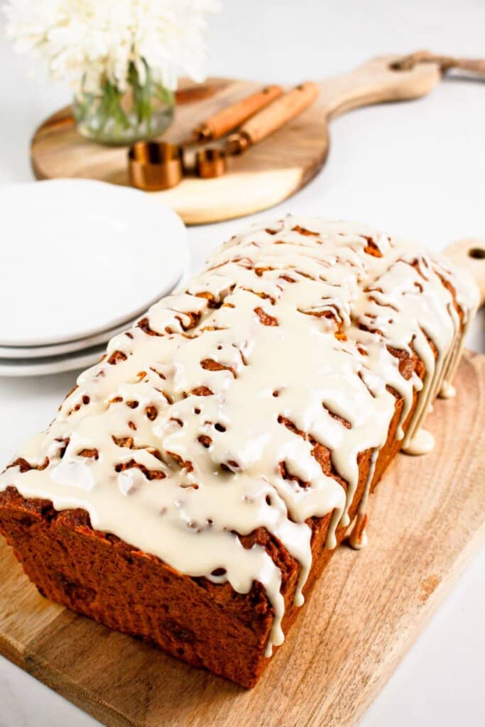 Loaf of pumpkin butterscotch bread on a wooden cutting board.