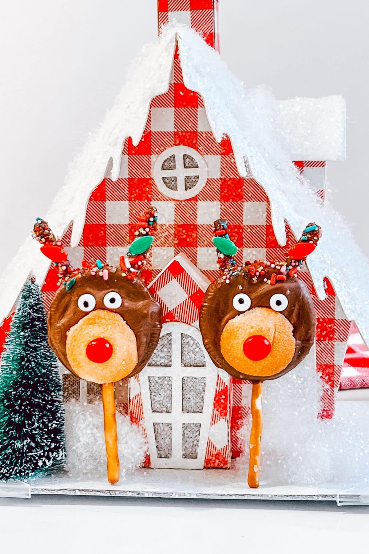 Two reindeer oreo pops on a house.