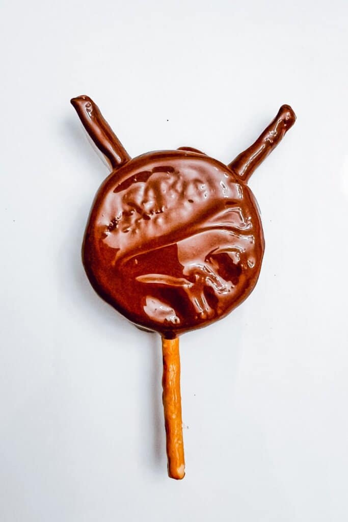 Cookie being dipped in chocolate.
