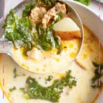 White bowl full of sausage potato and kale soup.