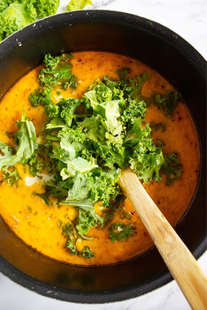 Kale being added to a pot.