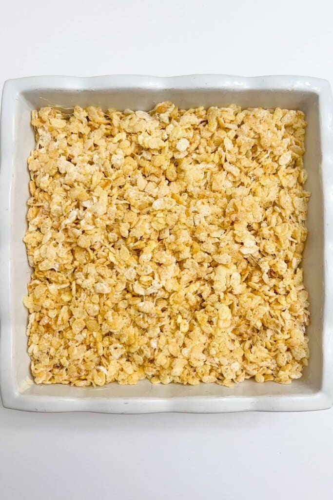 Cereal bars pressed into a square pan.