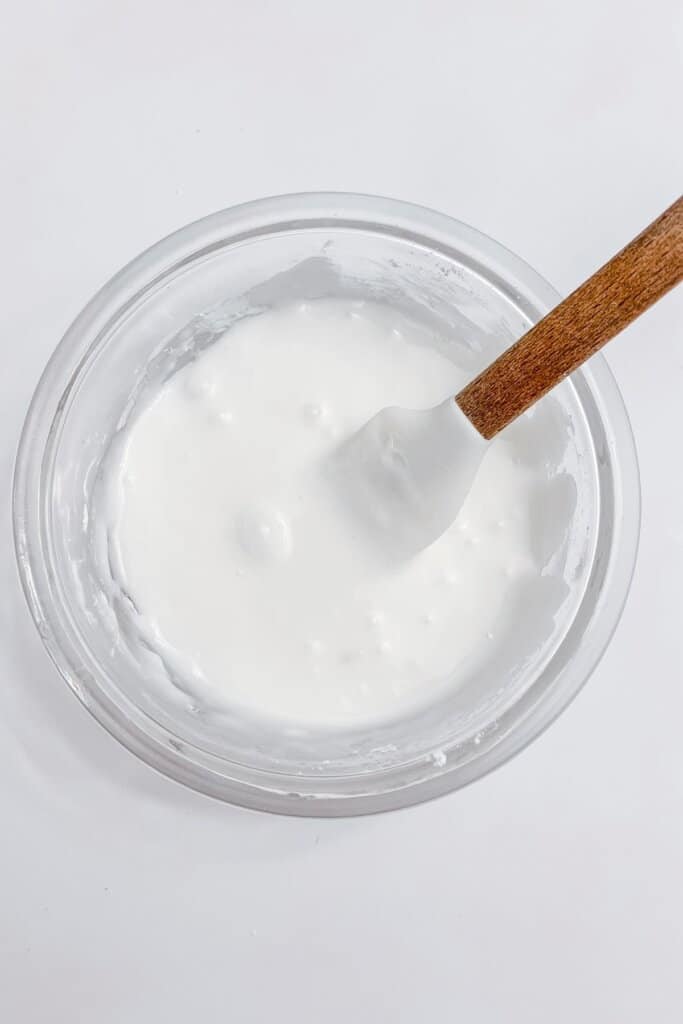 Icing being mixed in a bowl.