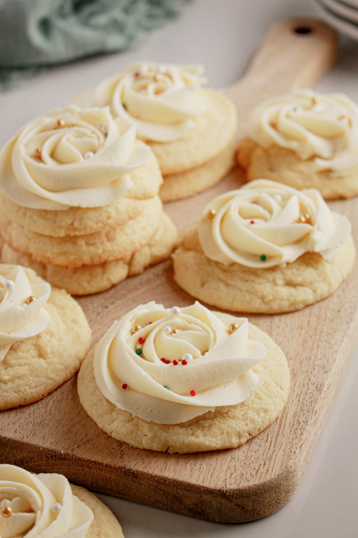 Soft frosted sugar cookies on a cutting board.