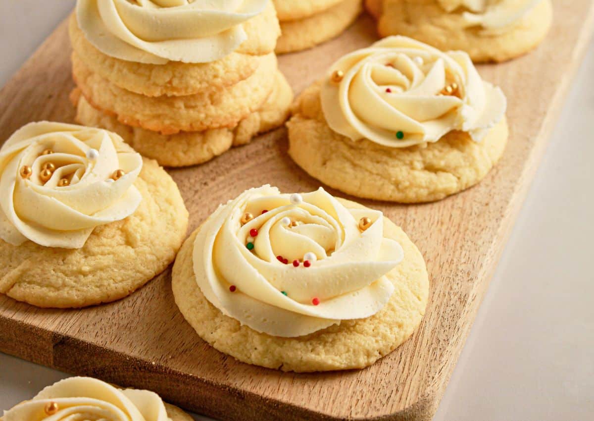 Soft frosted sugar cookies on a cutting board.
