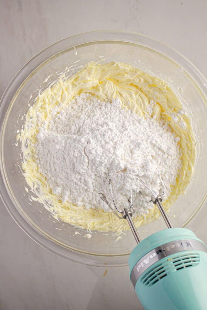 Butter and powdered sugar being mixed together.