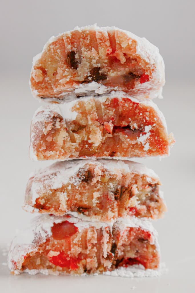 Four halves of cherry snowball cookies stacked on top of each other.