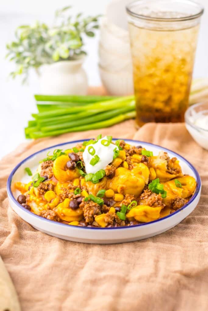 Plate full of beef enchilada tortellini on table.