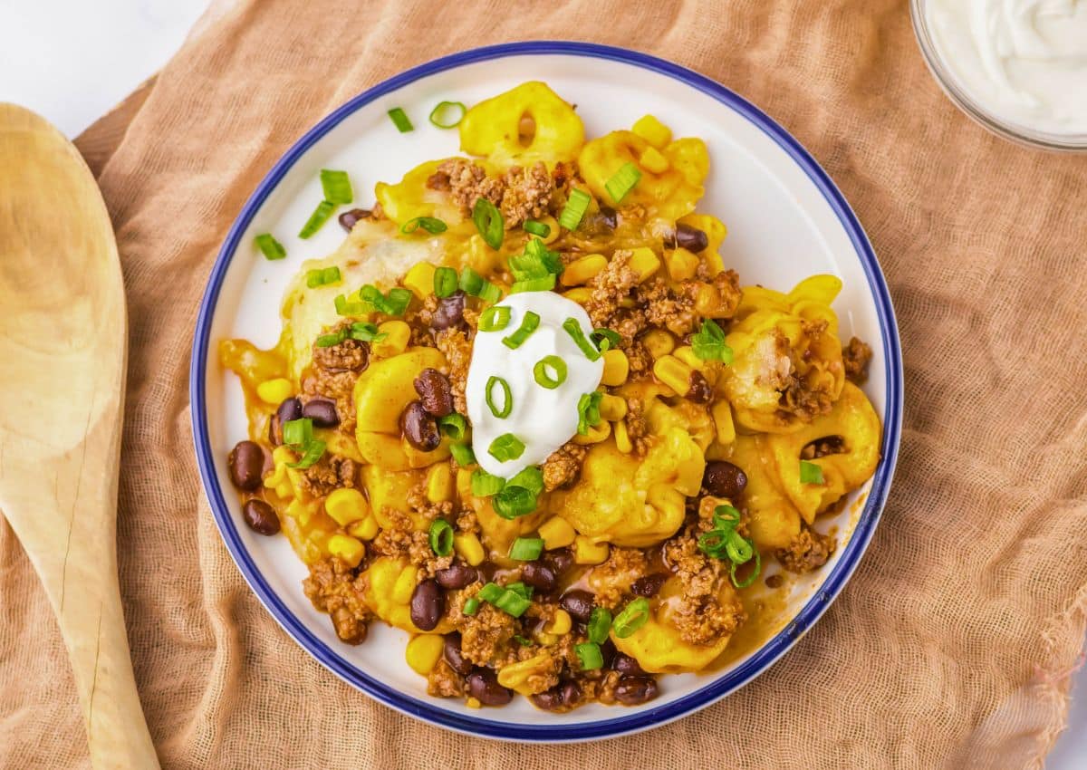 Plate full of beef enchilada tortellini on table.