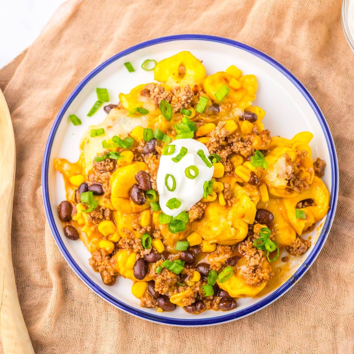 Plate full of beef enchilada tortellini on table.