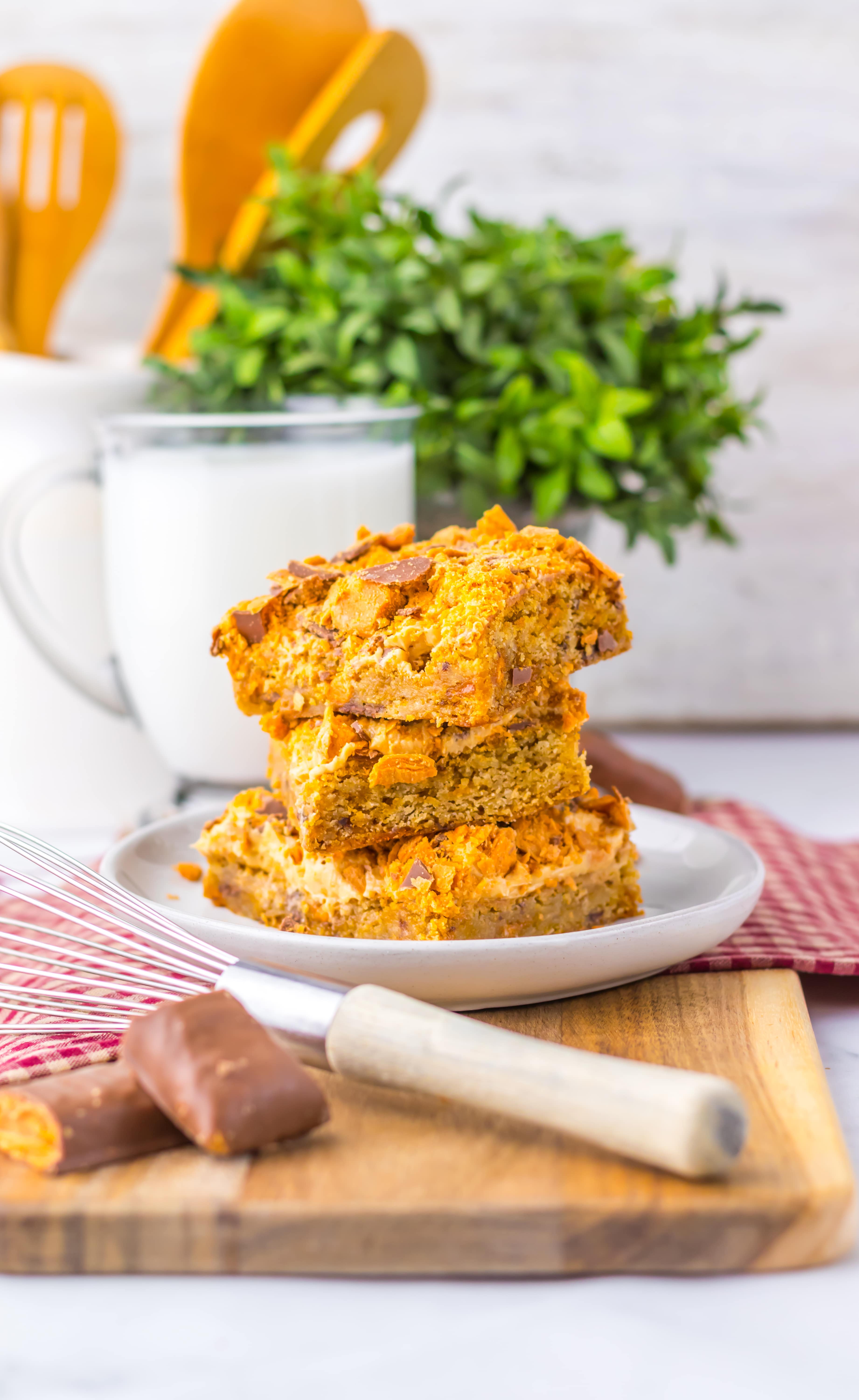 Three butterfinger cookie bars on a plate.