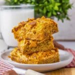 Three butterfinger cookie bars on a plate.