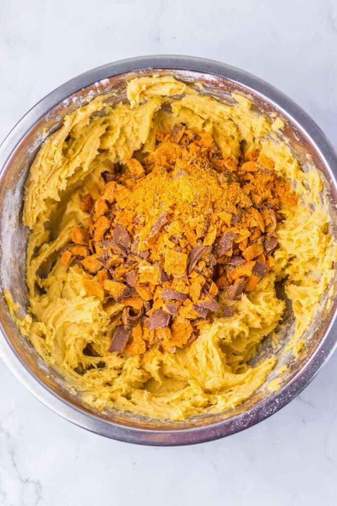 Chopped butterfingers in a metal mixing bowl.