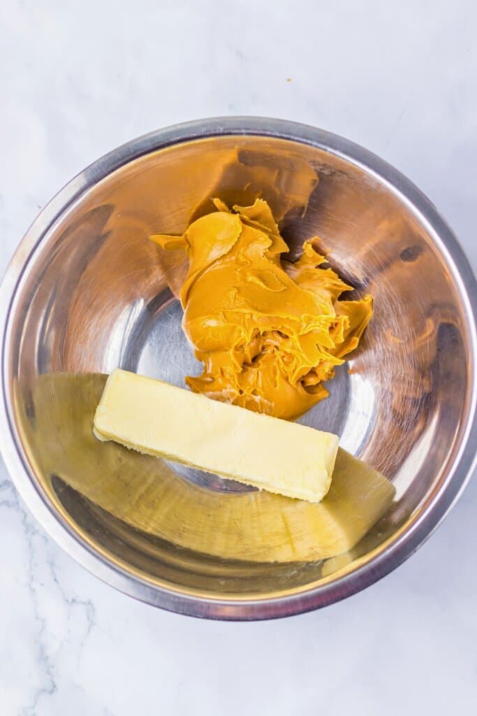 Peanut butter and butter in a metal mixing bowl.