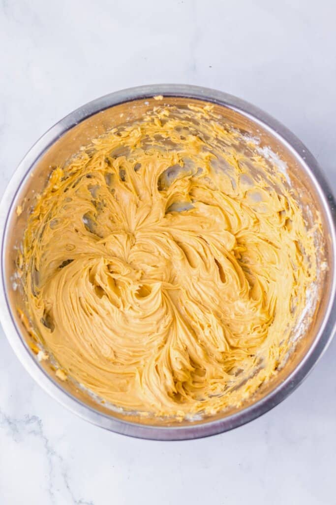 Peanut butter frosting in a metal mixing bowl.