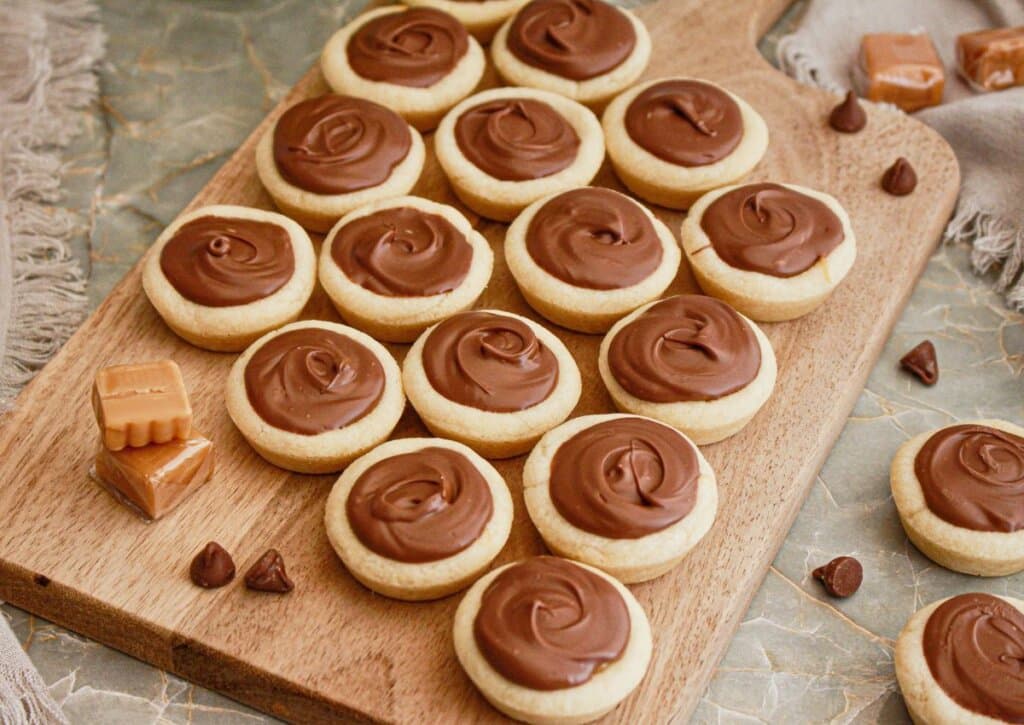 Caramel cookie cups on a wooden cutting board.