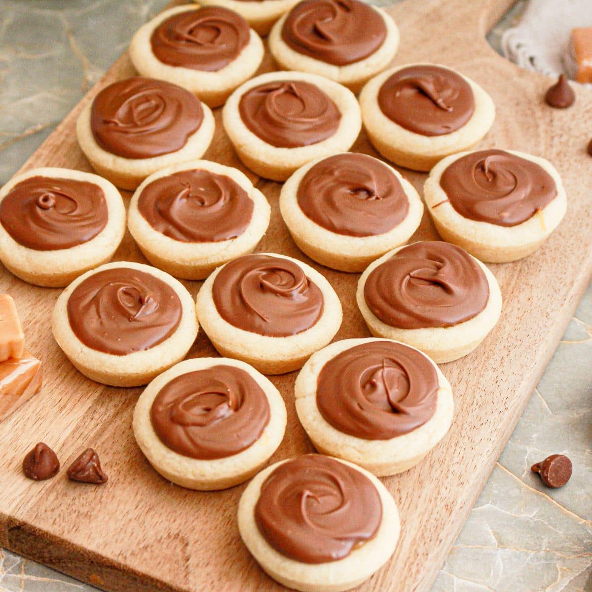 Caramel cookie cups on a wooden cutting board.
