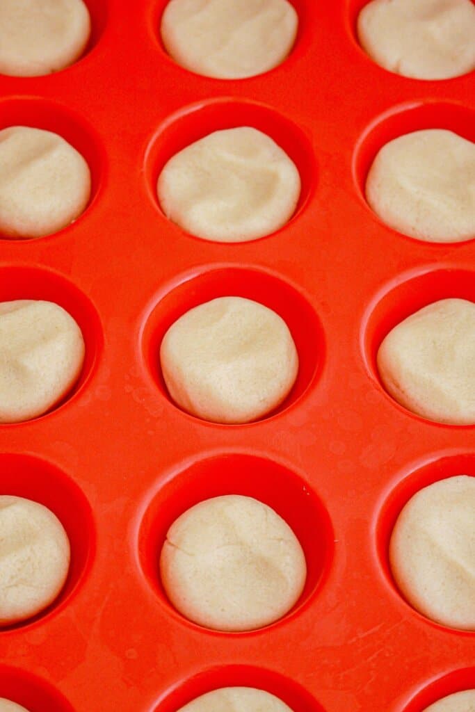Sugar cookie dough in a mini muffin pan.
