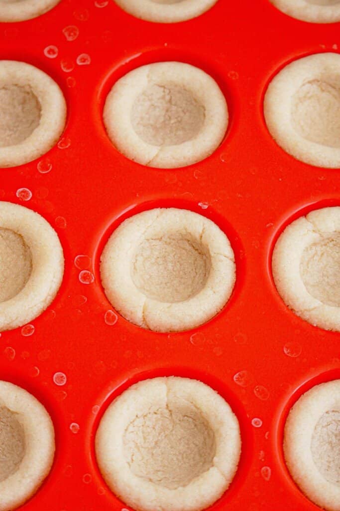 Sugar cookie cups in a mini muffin pan.
