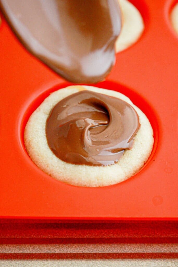 Chocolate being swirled on top of dessert.