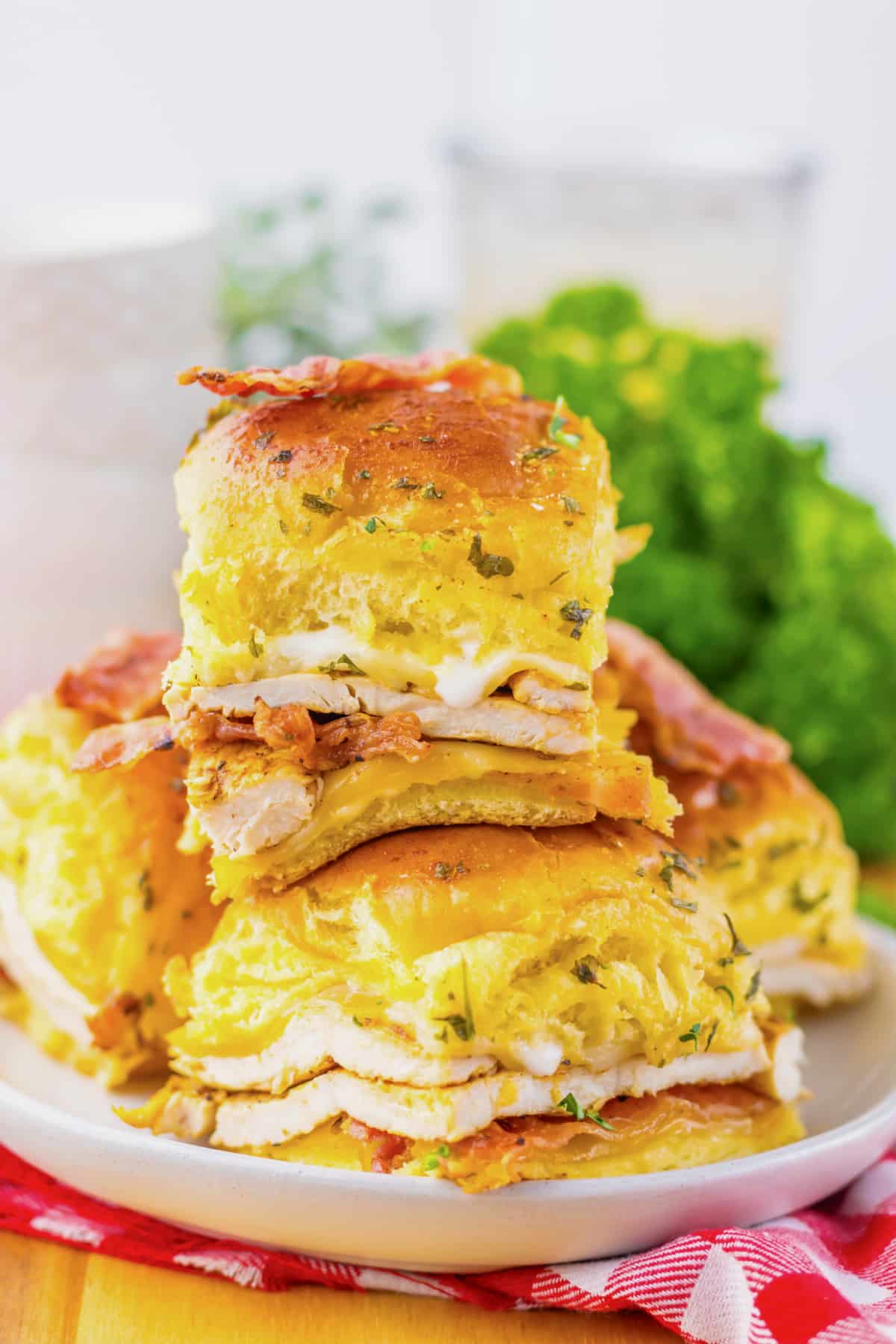 Chicken bacon ranch sliders stacked on a plate.