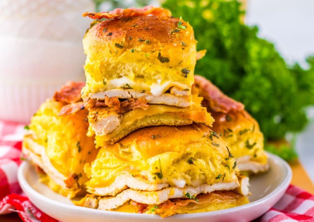Chicken bacon ranch sliders stacked on a plate.