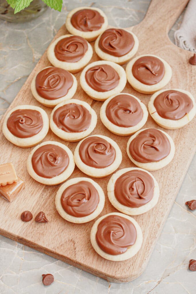 Caramel cookie cups on a wooden cutting board.