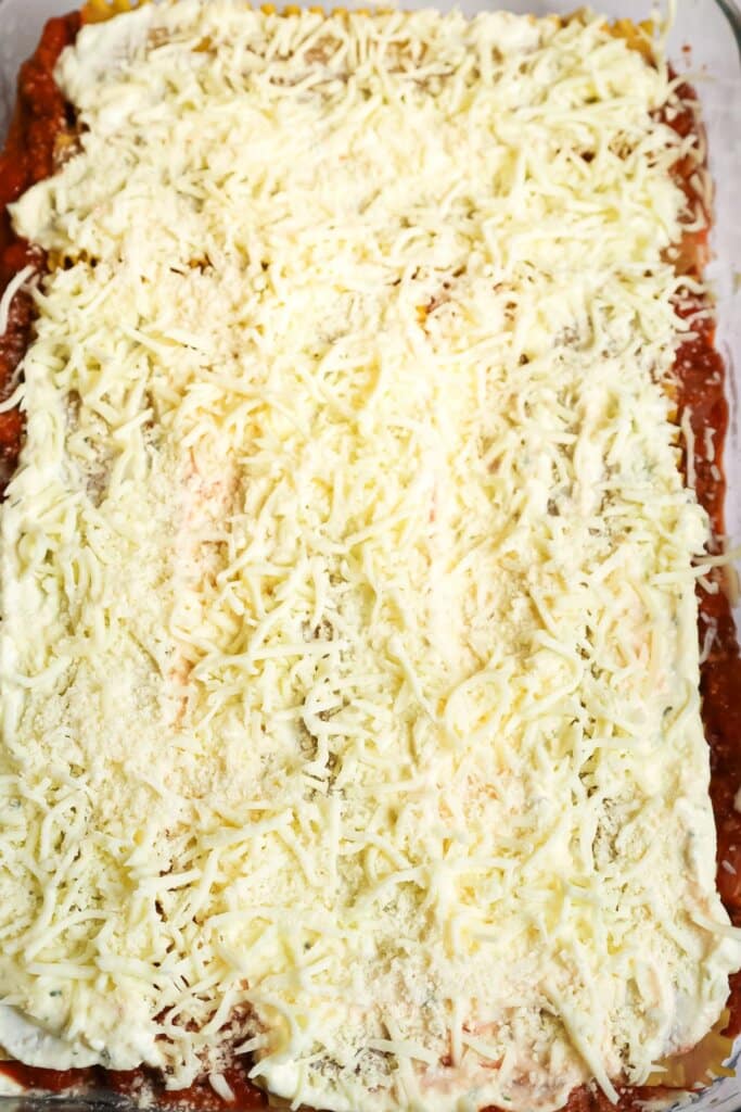 Cheese being sprinkled on top of meal.