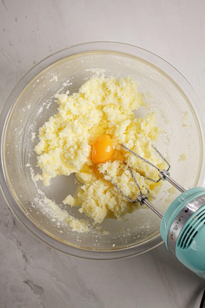 Eggs being mixed into butter and sugar.