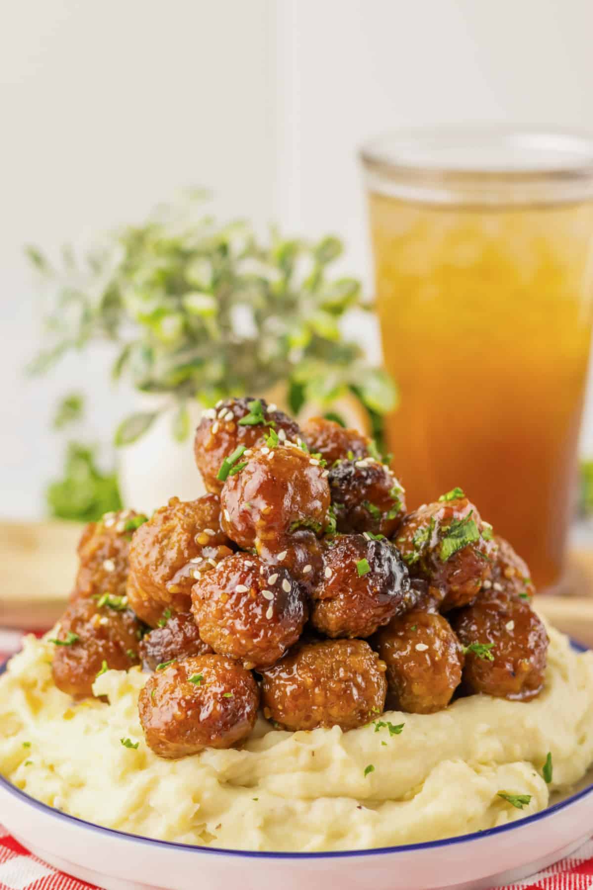 Mashed potatoes topped with honey garlic meatballs .