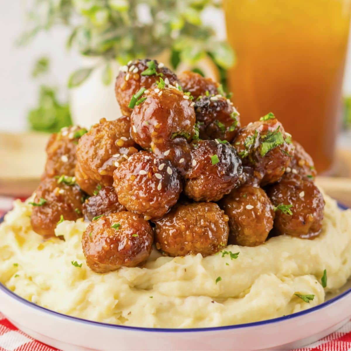 Mashed potatoes topped with honey garlic meatballs .