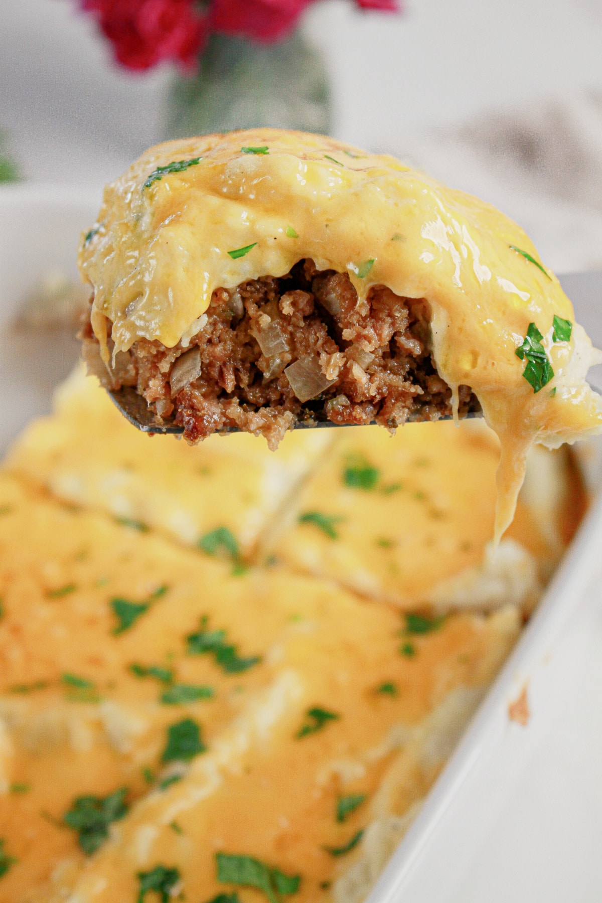 Slice of loaded potato meatloaf casserole on a plate.