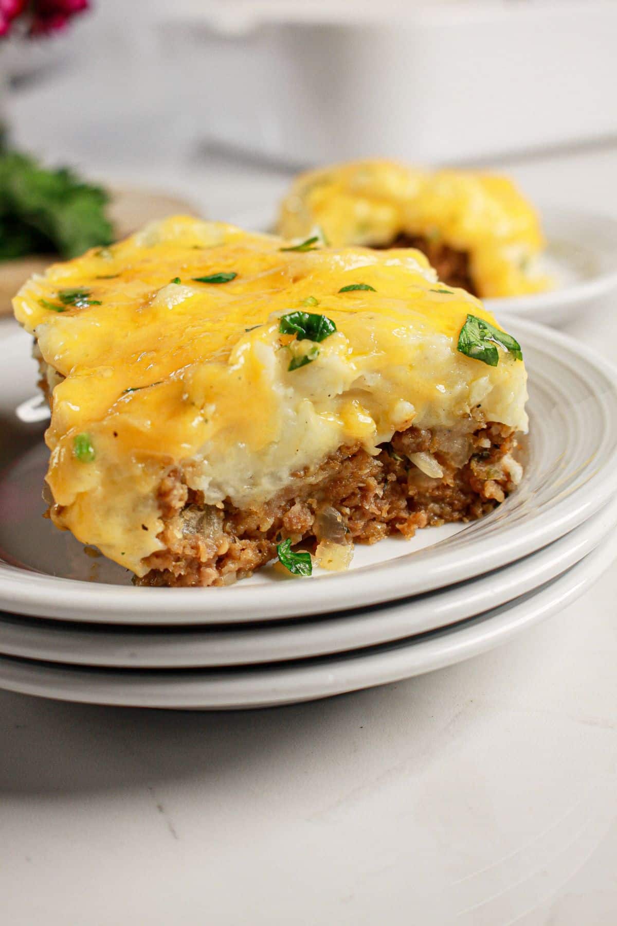 Slice of loaded potato meatloaf casserole on a plate.