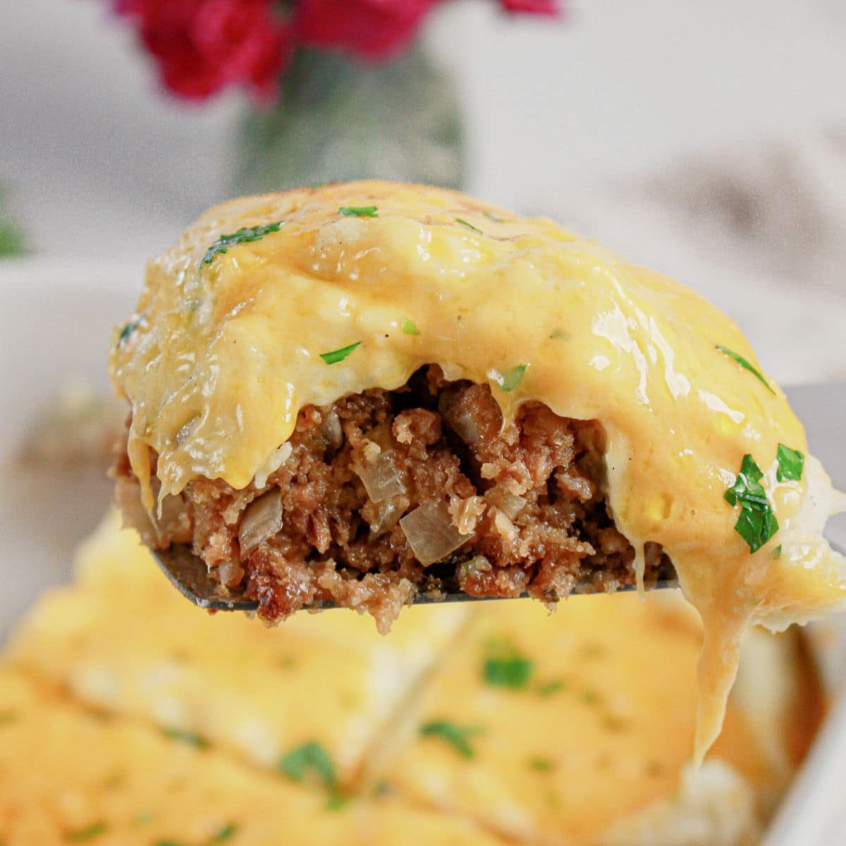 Slice of loaded potato meatloaf casserole on a plate.