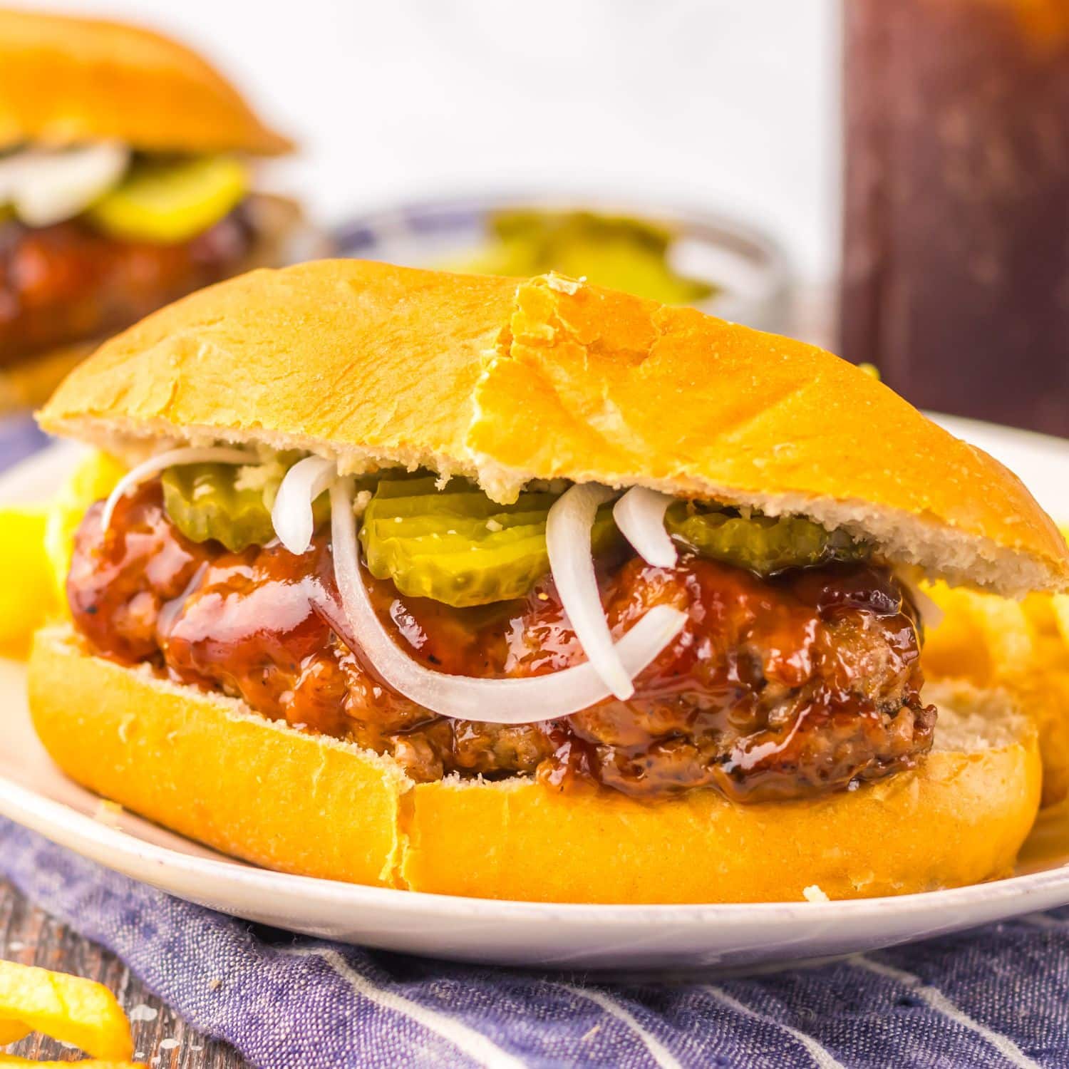 Mcrib sandwich on a plate with some fries.