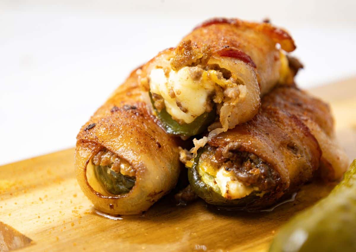 Pickle poppers stacked on a cutting board.