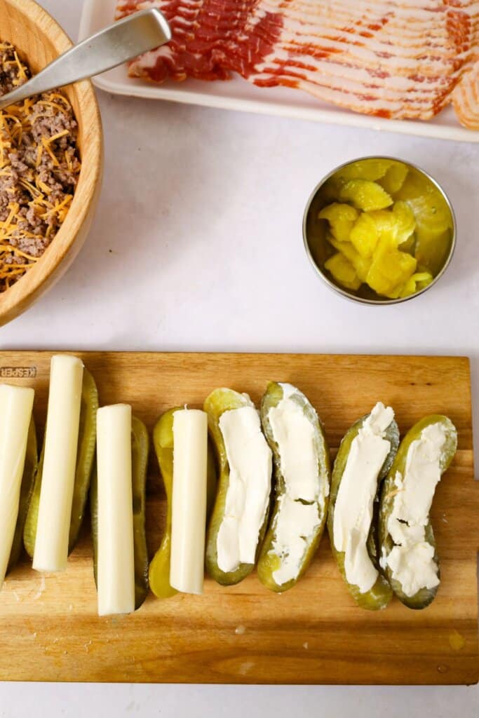 Cheese being stuffed into cucumber halves.