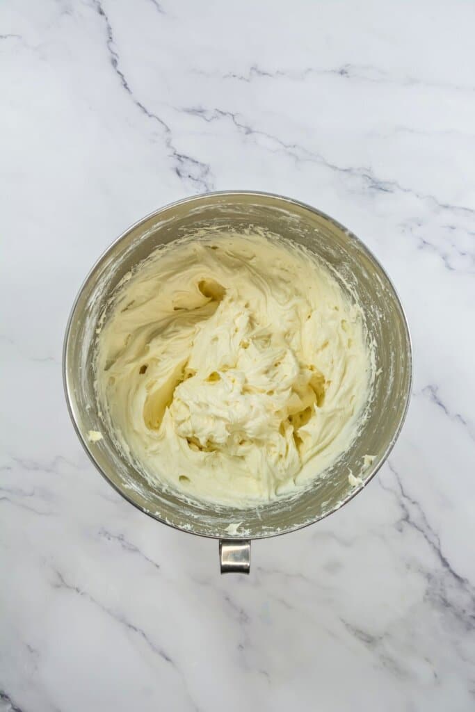 Frosting being mixed in a mixing bowl.