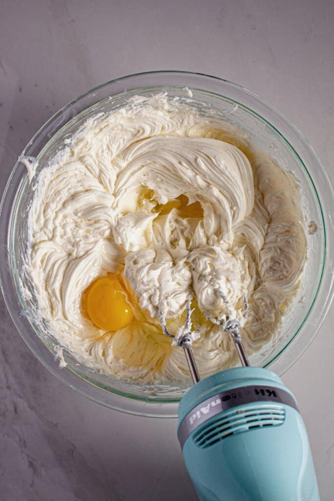 Eggs being mixed into cream cheese.