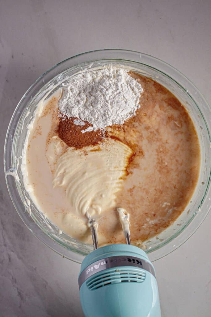 Cinnamon and cornstarch being mixed into batter.