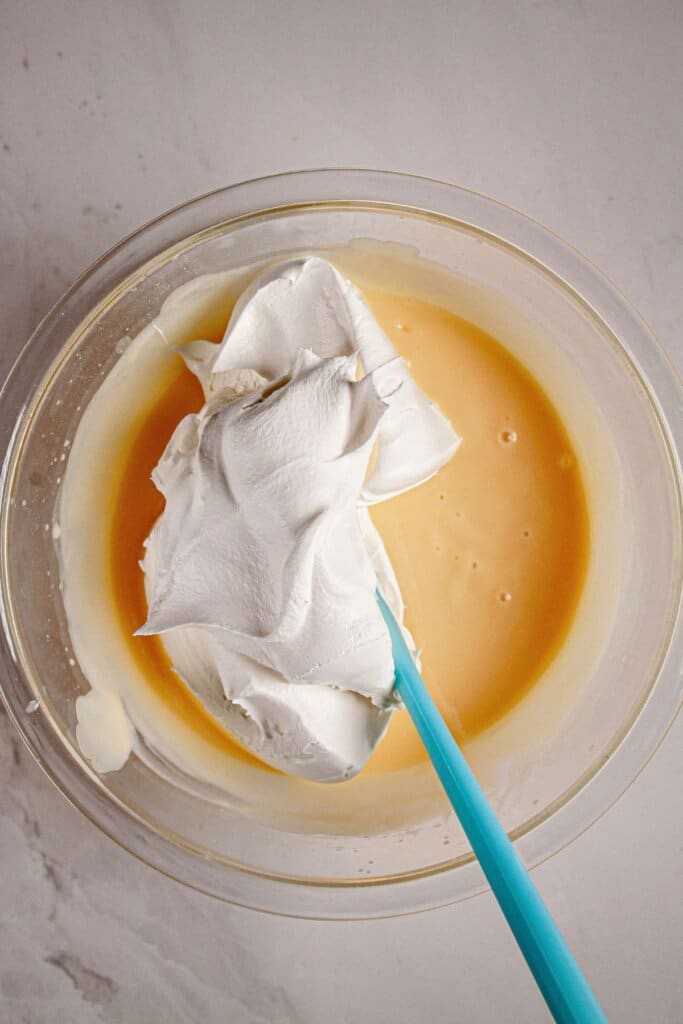Whipped topping being folded into batter.