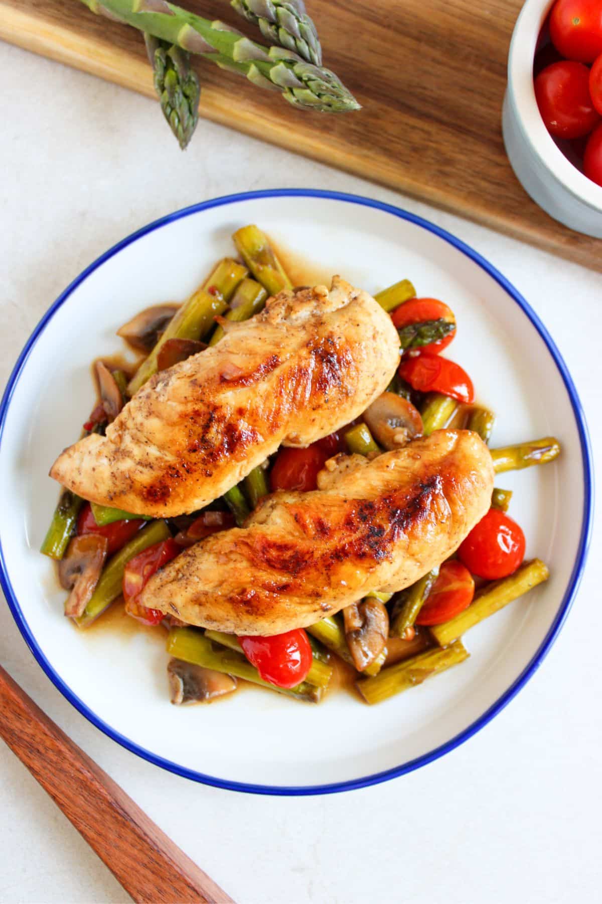 Chicken tenderloins on top of a bed of vegetables.