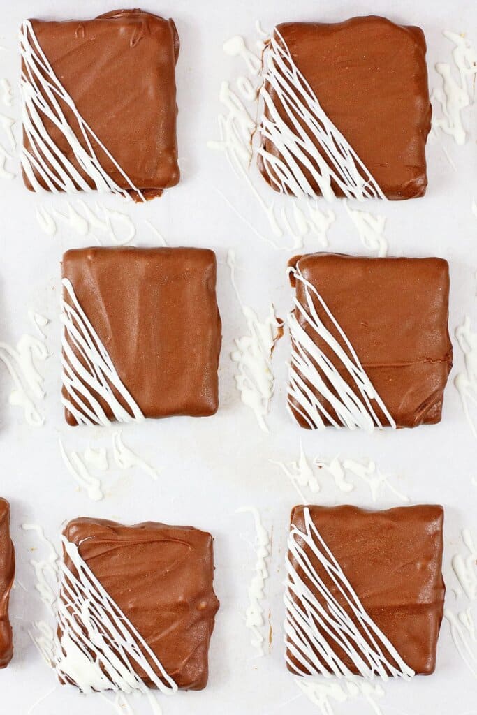 White chocolate being drizzled on graham crackers.
