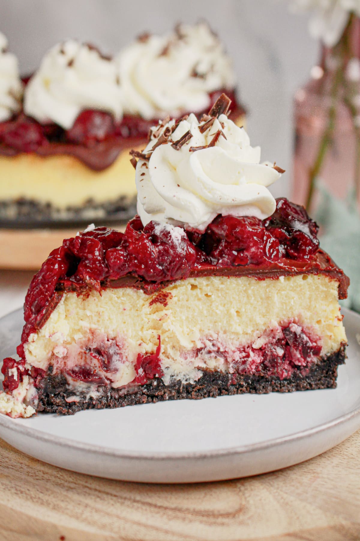 Slice of black forest cheesecake on a small plate.