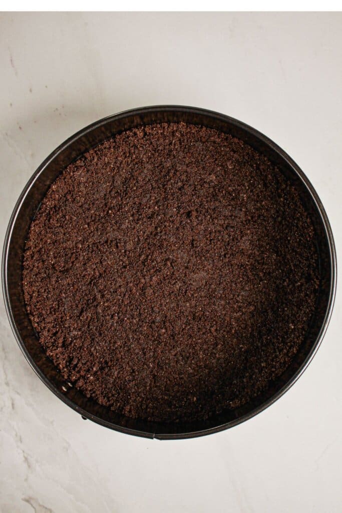 Oreo cookie crust pressed into the bottom of the springform pan.