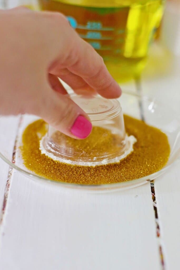Plastic cup being dipped in sprinkles.