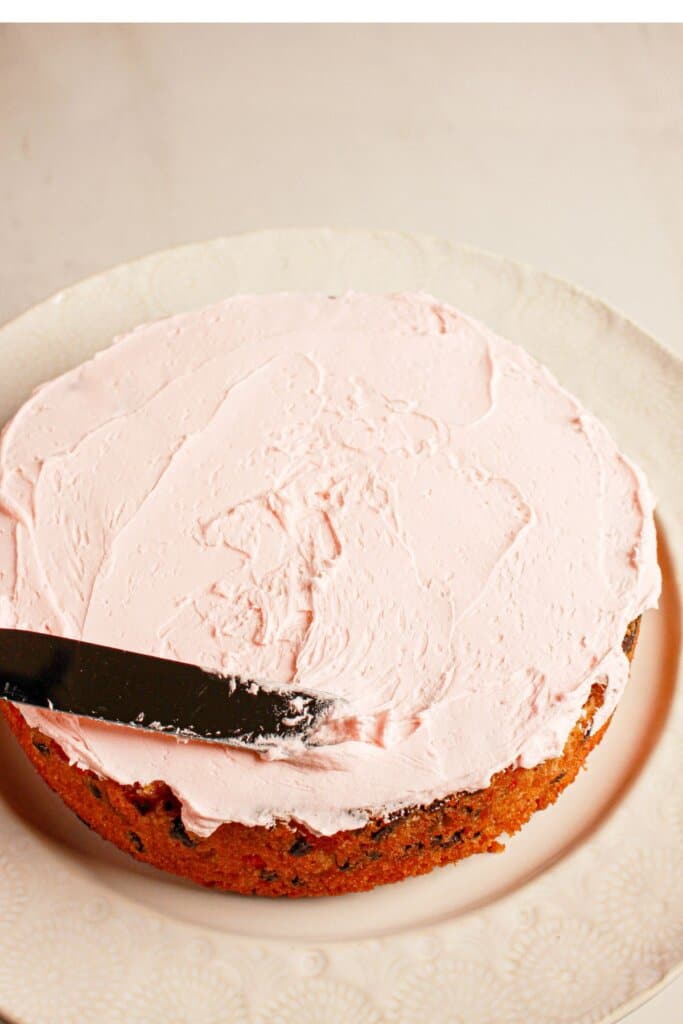Frosting being spread on top of a dessert in a plate.